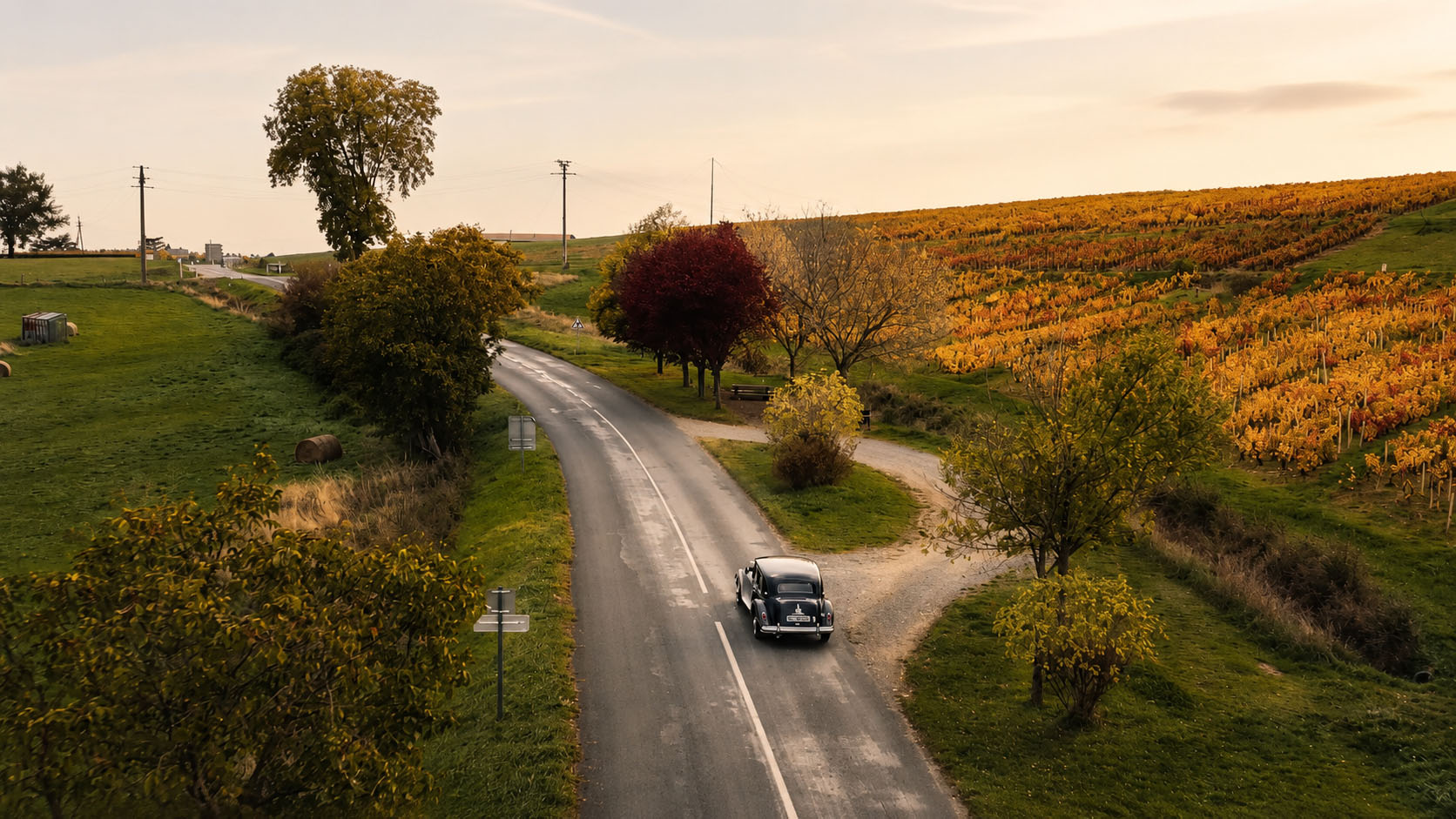 Voiture de collection sur une route du Beaujolais lors d’une escapade Esprit Légende